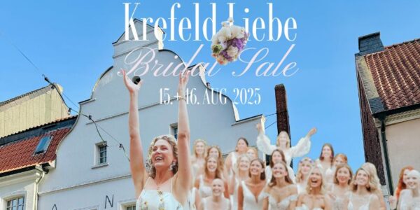 Eine lächelnde Braut wirft ihren Brautstrauß in einer Straße mit historischen Gebäuden in die Luft, während eine Gruppe von Frauen in weißen Kleidern hinter ihr jubelt. Der Text lautet: Krefeld Liebe Bridal Sale 15.-16. Aug 2025.
